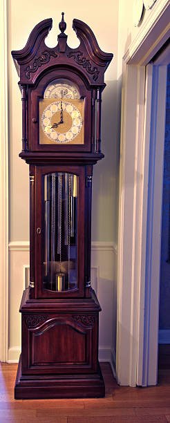 "Elegant mechanical chain-driven grandfather clock with intricate woodwork and a classic clock face, representing timeless craftsmanship and traditional timekeeping."